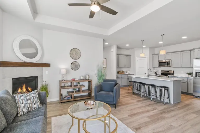 Lounge with a tray ceiling and fireplace in a representative Wild Oak ranch interior
